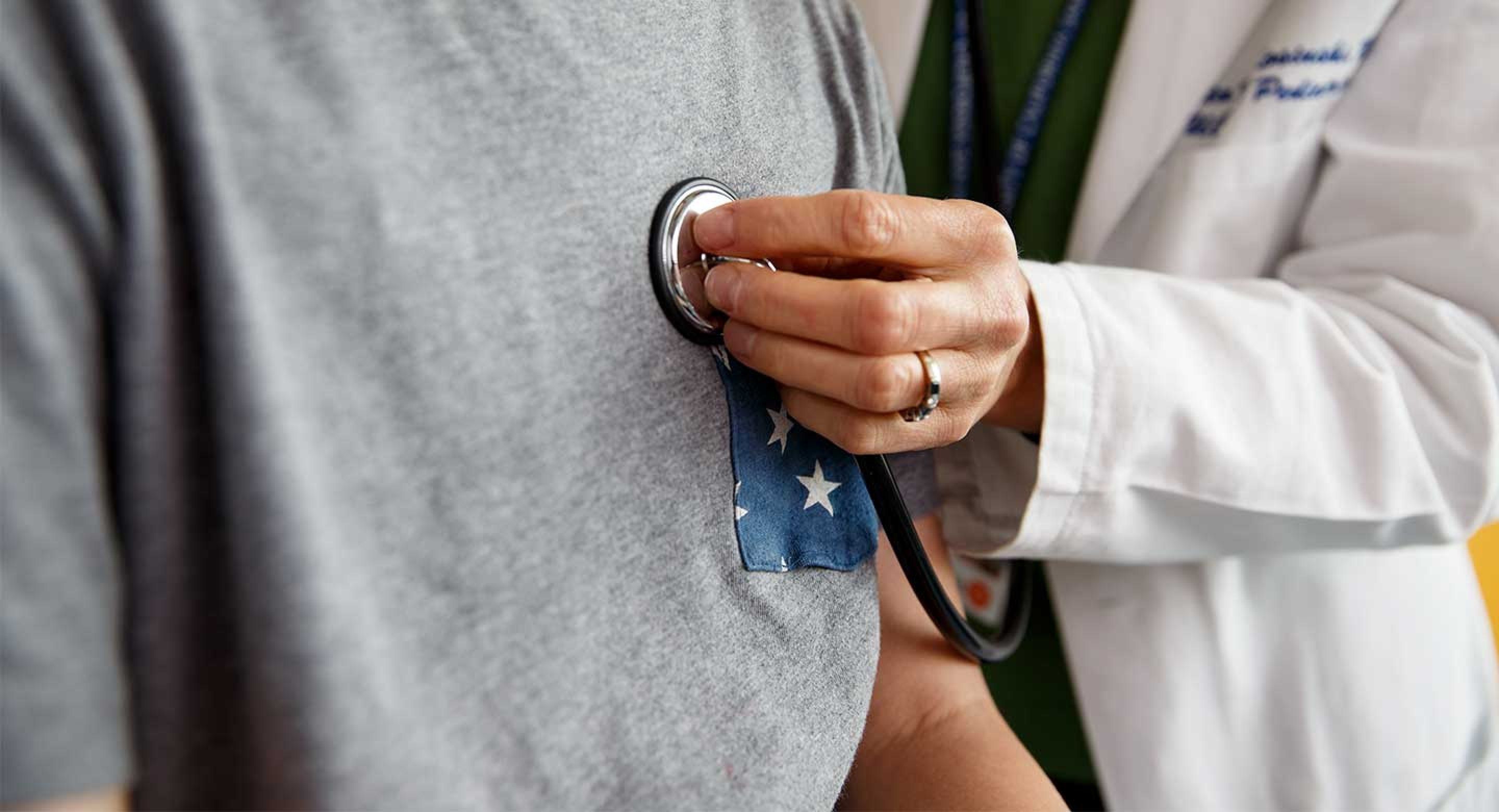 Care provider with stethoscope on patient