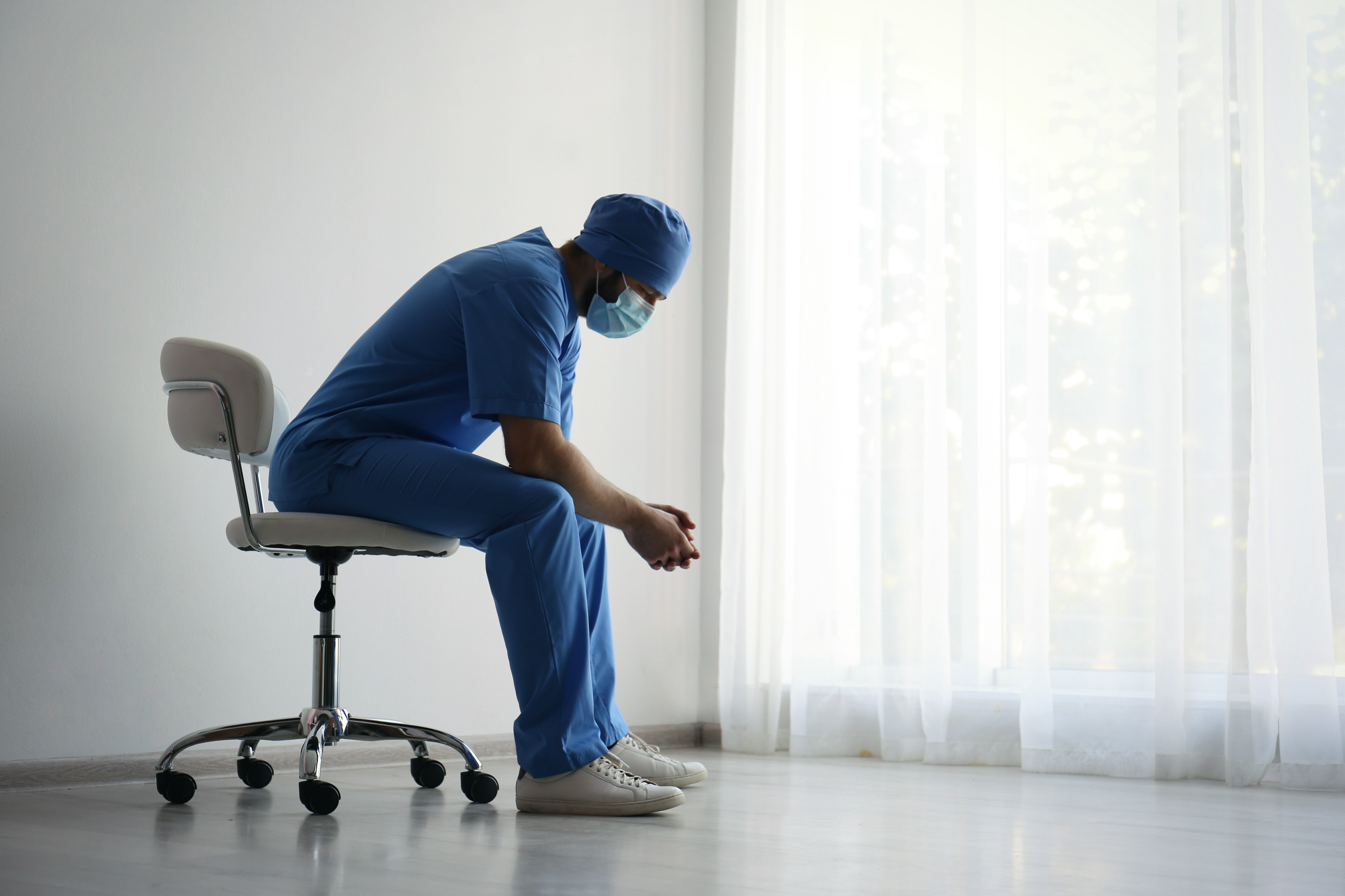 Clinician sitting in a chair with hands folded